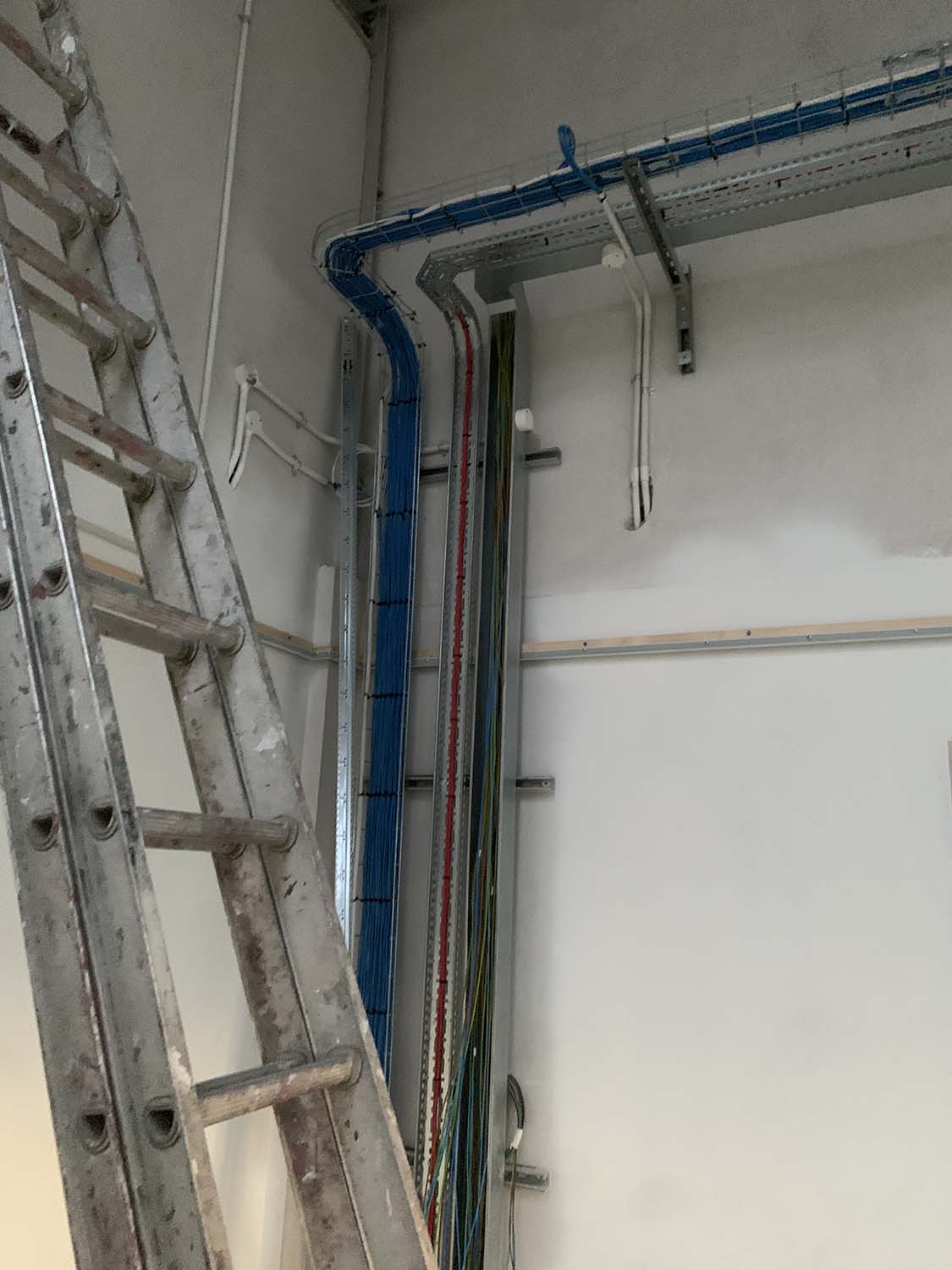 metal casing enclosing wiring up and across wall